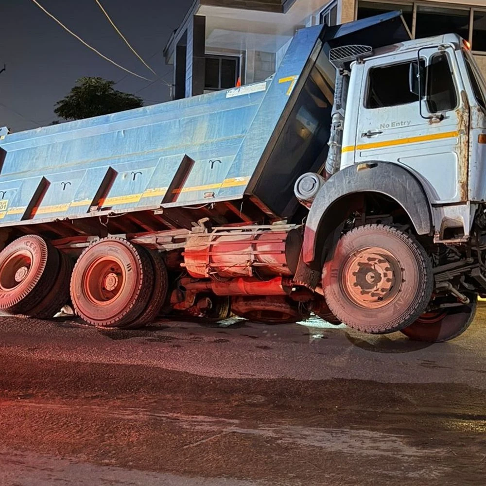 Tyre of a dumper filled with sand gets stuck in a pothole on Berna Road: Road sits near sewer lid; Pulled out of Hydra, impact on vehicular movement